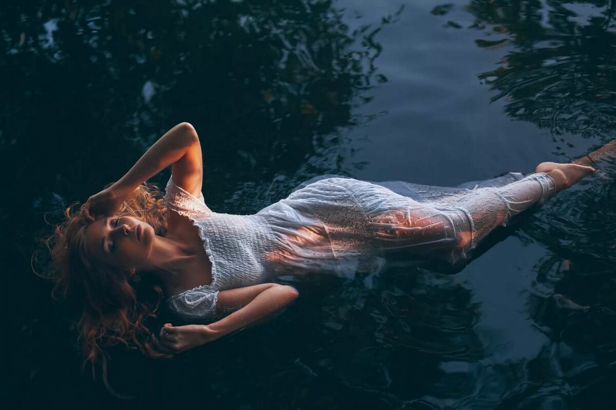 Сочная девушка показывает свое тело лежа в воде