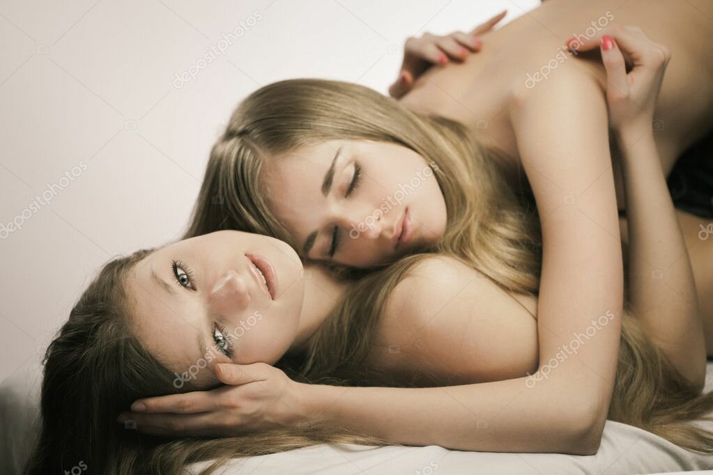 two young lesbian girls relaxing in a bed фото